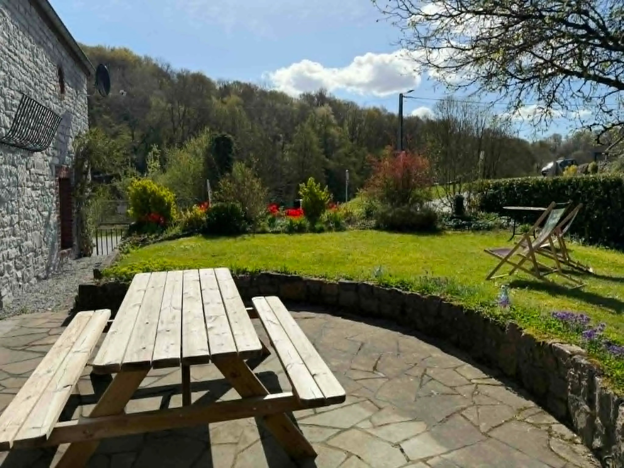 Table de pique-nique sur la terrasse du gîte, jardin et collines